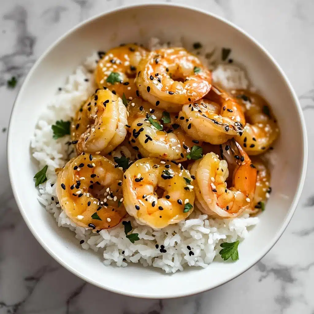 Ginger Garlic Sesame Shrimp, flavorful shrimp dishes, quick seafood recipe, stir-fry shrimp recipes, easy shrimp dinner Ideas The dish is presented in a white bowl with a layer of white rice at the bottom, showing a soft and fluffy texture. On top of the rice, there are several pieces of cooked shrimp with a light orange color, coated in a glossy light brown sauce. The shrimp are garnished with small black sesame seeds and finely chopped green herbs scattered on top and around. The bowl sits on a white marbled surface, adding a clean and bright background to the presentation.