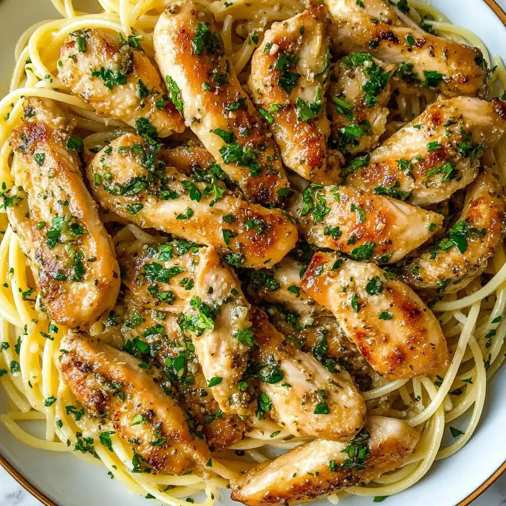 Chicken Scampi Pasta, easy chicken pasta dishes, flavorful garlic lemon pasta, quick weeknight dinner recipes, Italian-inspired chicken pasta The image shows a white plate filled with a bed of light yellow cooked spaghetti noodles, smooth and slightly glossy. On top, there are about ten golden brown cooked chicken strips, each with a crisp, slightly speckled surface from seasoning. The chicken pieces are spread evenly over the noodles and topped with small green chopped herbs and tiny bits of garlic sauce, adding texture and a fresh look. The whole dish rests on a white marbled surface.