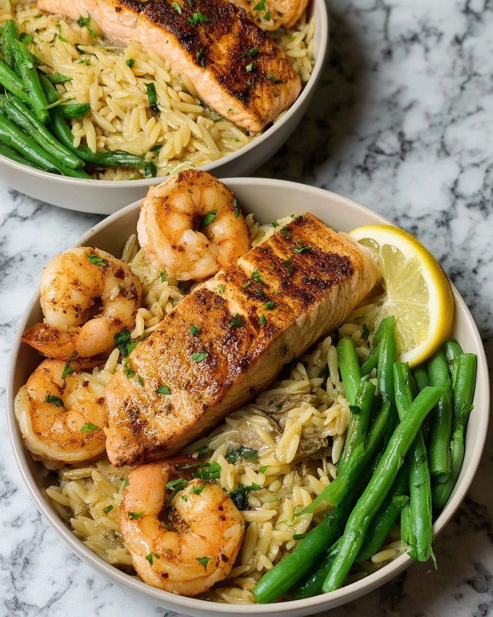 Two white bowls sit on a white marbled surface, each filled with a colorful seafood meal. The bottom layer in each bowl is creamy orzo pasta, light brown with bits of green herbs mixed throughout. On top of the orzo, there is a nicely seared, golden-brown piece of salmon placed mostly in the center, with some charred spots adding texture. Surrounding the salmon are several plump, orange shrimp with a light seasoning. To one side of each bowl, there is a small pile of bright green, cooked green beans. A thin lemon slice rests on the edge of the orzo near the green beans in each bowl, adding a fresh yellow and white contrast. The photo is taken with an iphone --ar 4:5 --v 7