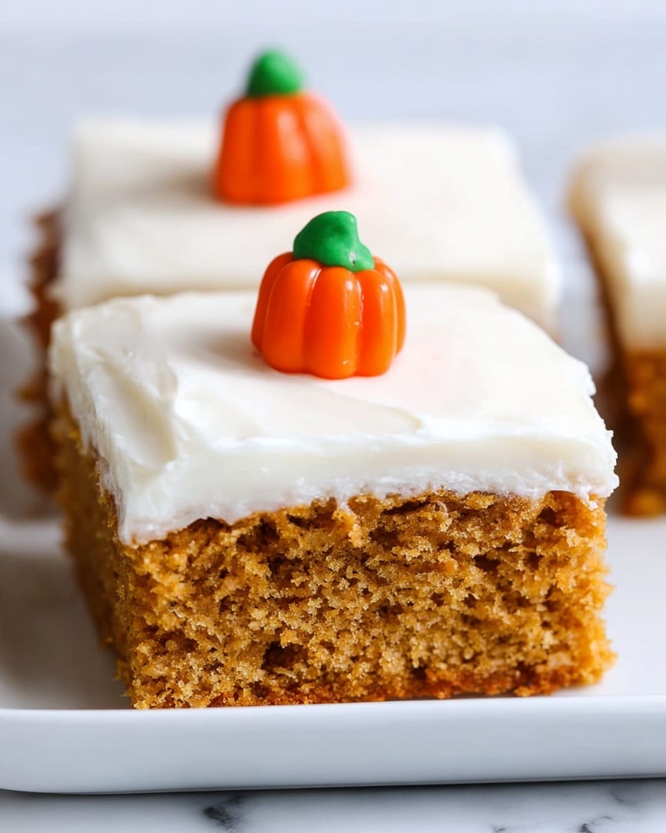 A single square piece of moist, light brown cake with a soft, smooth white frosting layer evenly spread on top. The cake is resting on a slightly scratched baking tray with more cake squares blurred in the background. A white utensil is lifting the piece, showing its thick, spongy texture in the light brown cake layer beneath the frosting. The background surface is a white marbled texture photo taken with an iphone --ar 4:5 --v 7