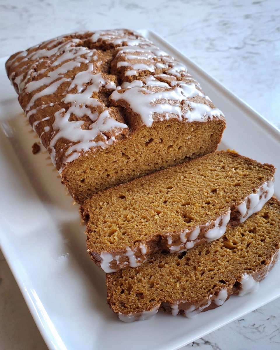 Two loaves of pumpkin bread sit side by side on a wooden board over a white marbled surface. Each loaf has one main layer of soft, light brown bread with a slightly crumbly texture. The tops are thick and golden-brown with cracks showing the fluffy inside. Thin, white icing drizzle goes back and forth in lines from one side to the other across the tops of the loaves, adding a light glossy layer. Photo taken with an iphone --ar 4:5 --v 7