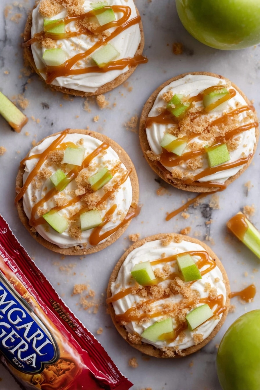 There are four round cookies on a white marbled surface, each cookie topped with a thick swirl of white cream. On top of the cream are small green apple pieces and light brown crumbly bits. Each cookie has thin lines of caramel-colored sauce drizzled over the cream and toppings. A few crumbs are scattered around the cookies. One green apple and a red bag of Imperial Sugar lie near the cookies. In the middle of the cookies is a small stick of green apple with the caramel sauce drizzled on it. photo taken with an iphone --ar 2:3 --v 7 - Caramel Apple Cookies, Caramel Apple Cookies Crumbl Copycat, Fall Cookies with Caramel and Apples, Soft Apple Cookies with Cinnamon, Easy Caramel Apple Cookie Recipe