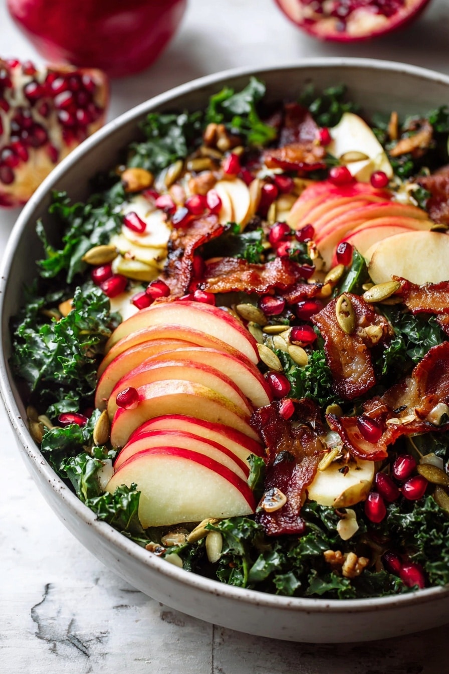 A white bowl filled with a fresh salad is placed on a white marbled texture. The bottom layer has dark green curly kale. On top, there are thinly sliced red apples arranged in small stacks showing red and light yellow skin with white inside. Bright red pomegranate seeds are scattered all over the salad, adding small round pops of color. There are pieces of crispy golden-brown bacon spread unevenly across the bowl. Small roasted pumpkin seeds are sprinkled lightly over the salad, giving a crunchy texture. The colors are deep green, red, and brown with a mix of soft and crispy textures. Photo taken with an iphone --ar 2:3 --v 7 - Fall Harvest Honeycrisp Apple and Kale Salad, seasonal fall salad with apples and kale, healthy autumn salad recipe, easy fall kale salad, honeycrisp apple salad