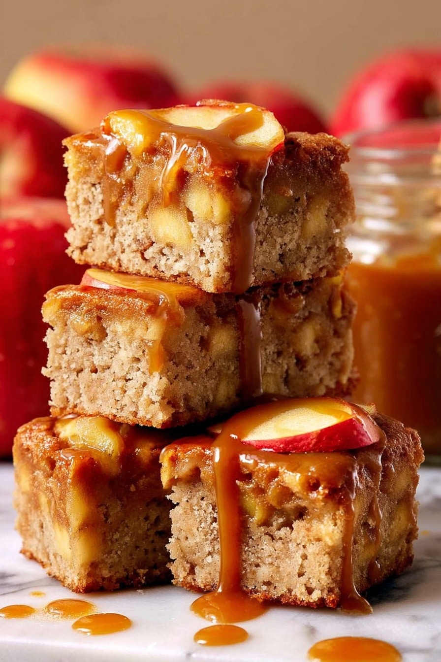 The image shows four thick square pieces of apple cake stacked on each other on a white marbled surface. Each piece has a light brown, porous texture with visible chunks of apple inside and apple slices on top. The top layer is covered in a shiny, caramel brown sauce that drips down the sides of the cake pieces. In the background, there are red apples and a glass jar filled with caramel sauce, slightly blurred. The lighting highlights the moist texture of the cake and the glossy caramel sauce photo taken with an iphone --ar 2:3 --v 7 - Caramel Apple Cake, fall dessert recipes, apple cake with caramel, cozy autumn desserts, easy apple cake recipe