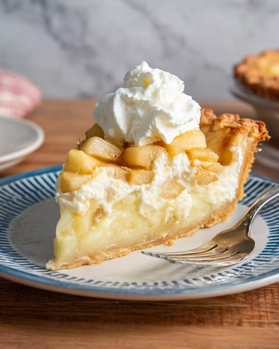 The image shows a round apple tart with a golden-brown crust on a white plate placed on a round wooden board with a handle. The tart's top layer has small, square apple pieces arranged evenly, with a shiny, slightly caramelized surface. One slice is taken out and placed on a white plate with blue stripes around the edge, positioned to the left of the tart. A silver fork rests on the plate next to the slice. A white cup with a creamy beverage is in the top left corner on a white marbled surface, which serves as the background. A white cloth with a blue check pattern is folded near the wooden board. Photo taken with an iphone --ar 4:5 --v 7