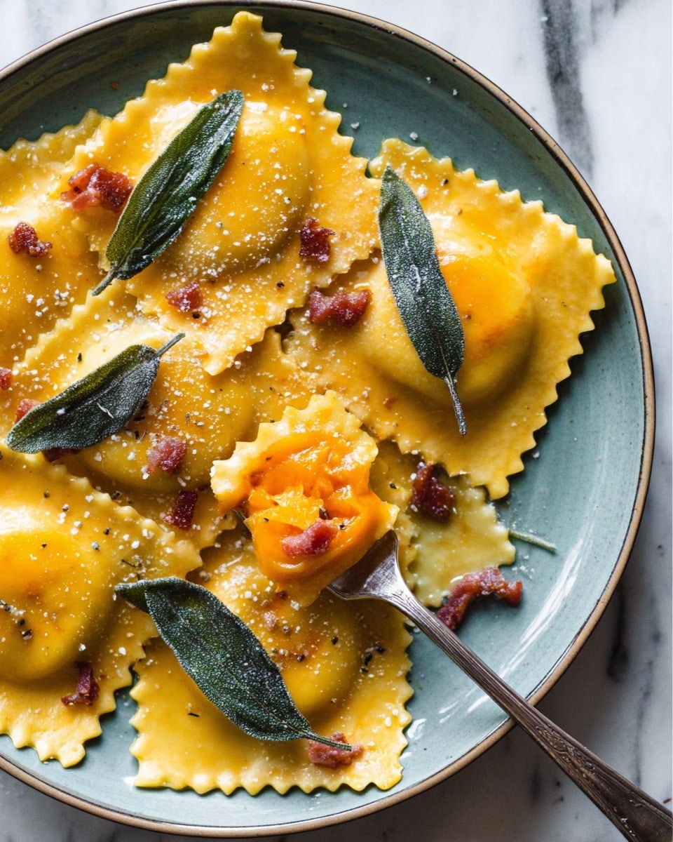 A white plate holds six large ravioli pasta pieces filled with bright orange filling. The ravioli have a slightly glossy and soft texture with crimped edges. On top of the pasta are three fried sage leaves with a slightly rough texture and a light dusting of salt. Several small browned bacon bits are scattered over the ravioli. A silver fork lifts one piece of ravioli, showing the orange filling inside. The background is a white marbled surface. photo taken with an iphone --ar 4:5 --v 7