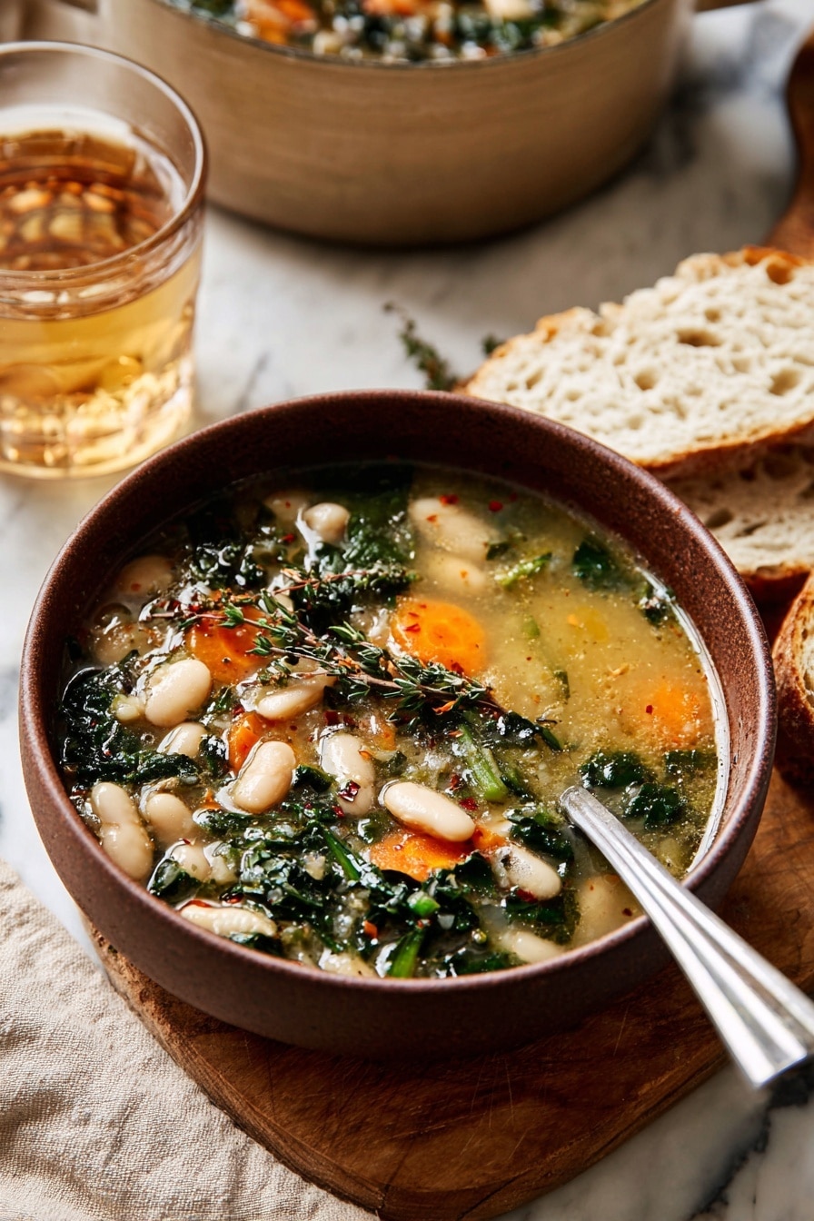 A bowl of soup with light golden broth fills the bowl, showing two layers of ingredients: the first layer has white beans and bright orange carrot slices, while the second layer includes dark green leafy herbs and some small herbs sprinkled on top. The bowl is brown and sits on a wooden board with pieces of white bread beside it. A shiny silver spoon rests inside the bowl. Behind the bowl, a clear glass of light brown drink and a large beige pot can be seen, all placed on a white marbled surface with a beige cloth underneath. Photo taken with an iphone --ar 2:3 --v 7 - Creamy Tuscan White Bean Soup, easy Tuscan bean soup, hearty white bean soup, vegan Tuscan soup, healthy white bean recipes