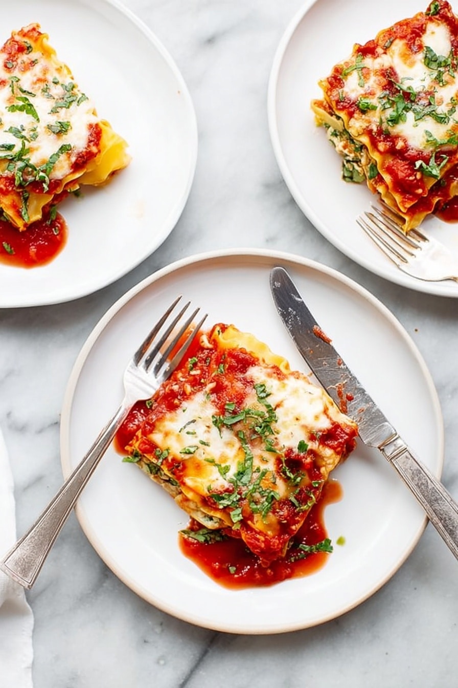 There are three white plates on a white marbled surface, each with a square piece of lasagna. Each lasagna piece has visible layers: a red tomato sauce at the bottom, a yellow pasta sheet, white cheese melted on top with some browned spots, and green herbs sprinkled over all. One plate in the middle has a fork and a knife resting on the edges, the knife laying diagonally across the plate. The tomato sauce slightly spreads around each lasagna piece, adding a bright red contrast to the white plates and light background. Photo taken with an iphone --ar 2:3 --v 7 - Spinach Lasagna Roll Ups, healthy lasagna roll ups, easy spinach lasagna, cheesy spinach roll ups, dinner ideas with spinach