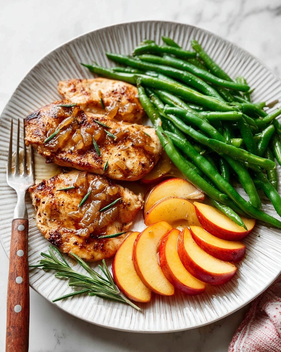 A white ridged plate holds a meal with three main parts: on the left are two pieces of browned, cooked chicken with a glossy, slightly oily surface and small bits of cooked onion on top, resting on a bed of thin, soft-looking slices of yellow apple with red edges. On the right side of the plate is a bunch of bright green steamed green beans stacked in a pile, smooth and shiny. The front piece of chicken is topped with three slices of cooked apple, glistening with sauce, and a small sprig of green rosemary lies between the apple slices. A fork with a wooden handle and metal prongs is at the bottom left corner of the plate, with a piece of chicken on the fork, held by a woman’s hand outside the frame. The plate is placed on a white marbled surface. photo taken with an iphone --ar 4:5 --v 7