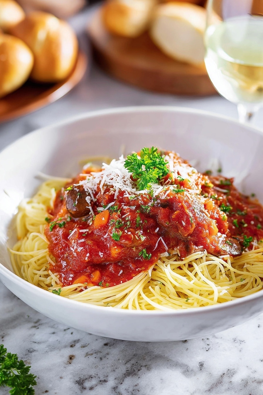 A white bowl filled with a bed of yellow spaghetti noodles forms the bottom layer, topped with red tomato sauce mixed with dark brown mushroom pieces and a piece of cooked white meat covered in sauce at the center. White shredded cheese is sprinkled lightly over the sauce and meat, and a small green parsley sprig sits on top for garnish. A golden brown breadstick lies diagonally on the left edge of the bowl. The bowl is placed on a white marbled surface with a metal fork resting inside the bowl on the right side, partially under the sauce. Photo taken with an iphone --ar 2:3 --v 7 - Slow Cooker Chicken Cacciatore, Chicken Cacciatore recipe, Italian chicken stew, easy slow cooker chicken, comforting chicken dinner