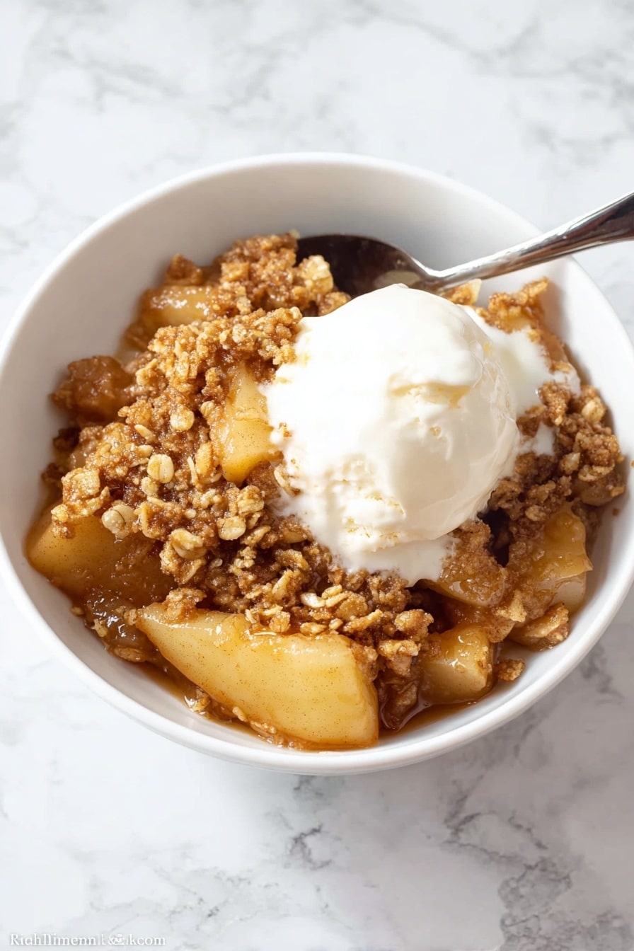 A close-up view of a white bowl filled with a warm apple dessert that has three main layers: a soft layer of sliced cooked apples with a light golden color on the bottom and middle, covered by a thick, sticky caramel sauce that gives a shiny, wet look, and topped with a crumbly, brown oat topping that looks crunchy with small clusters scattered unevenly on top. The dish looks moist and inviting, with the caramel sauce slightly dripping between the apple slices and crumbs. The white bowl sits against a white marbled surface. Photo taken with an iphone --ar 2:3 --v 7 - Healthy Apple Crisp with Oat-Pecan Topping, healthy apple crisp, gluten-free apple dessert, low-sugar apple crisp, nutritious fruit crisp