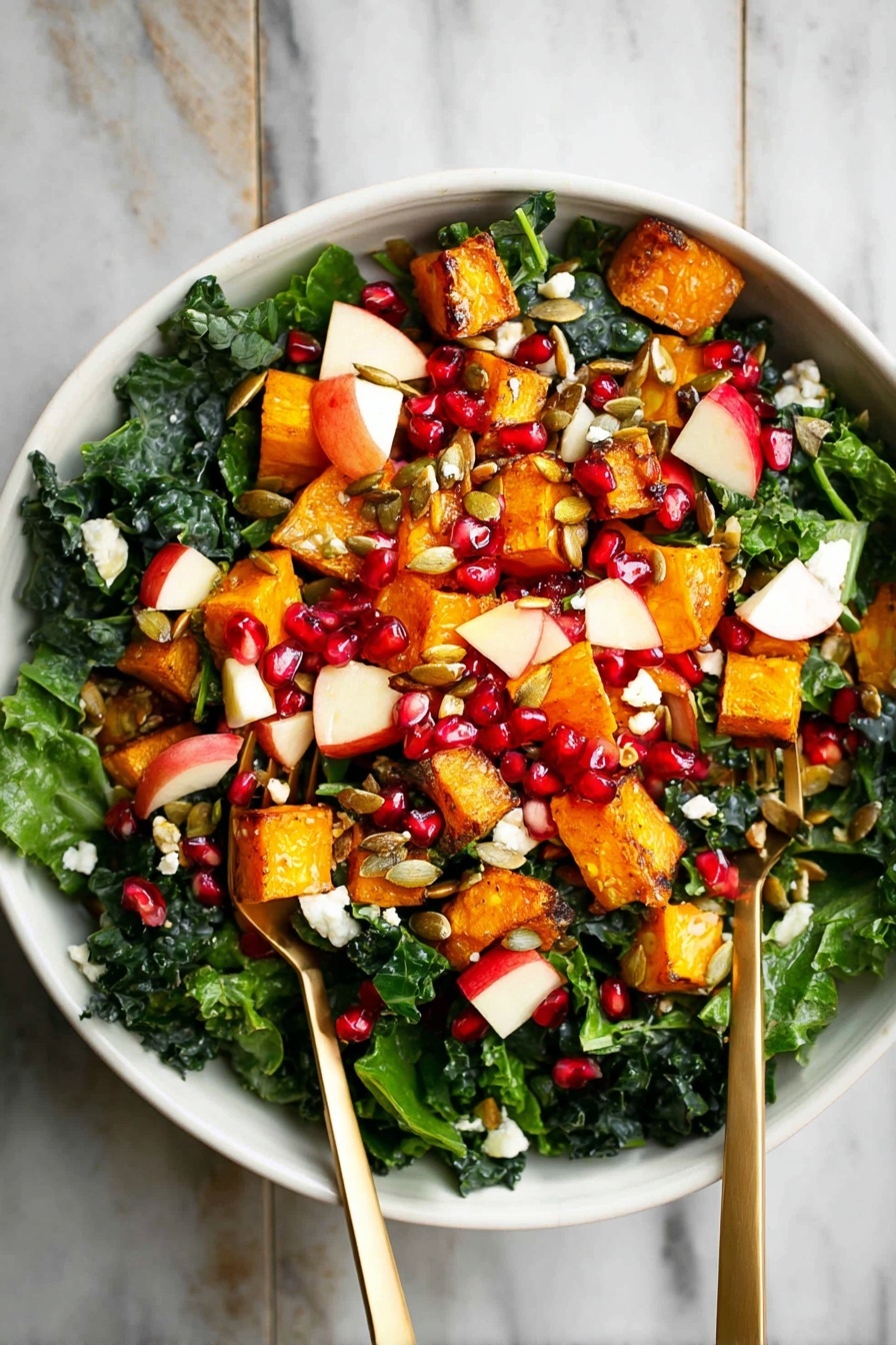 A white bowl filled with a colorful salad sits on a white marbled surface. The salad has three main layers: at the bottom, there are dark green kale leaves, fresh and leafy. On top of the kale, there are medium-sized orange roasted cubes of squash scattered around. Mixed in with these are small pieces of red apple with white inside, bright red pomegranate seeds, and some white small chunks of cheese. The salad is finished with some brown pumpkin seeds sprinkled evenly. Two metallic gold forks are placed inside the bowl, one on each side. Photo taken with an iphone --ar 2:3 --v 7 - Fall Butternut Squash Apple Salad, autumn squash apple salad, seasonal fall salad with butternut squash, healthy fall salad recipes, easy autumn vegetable salad