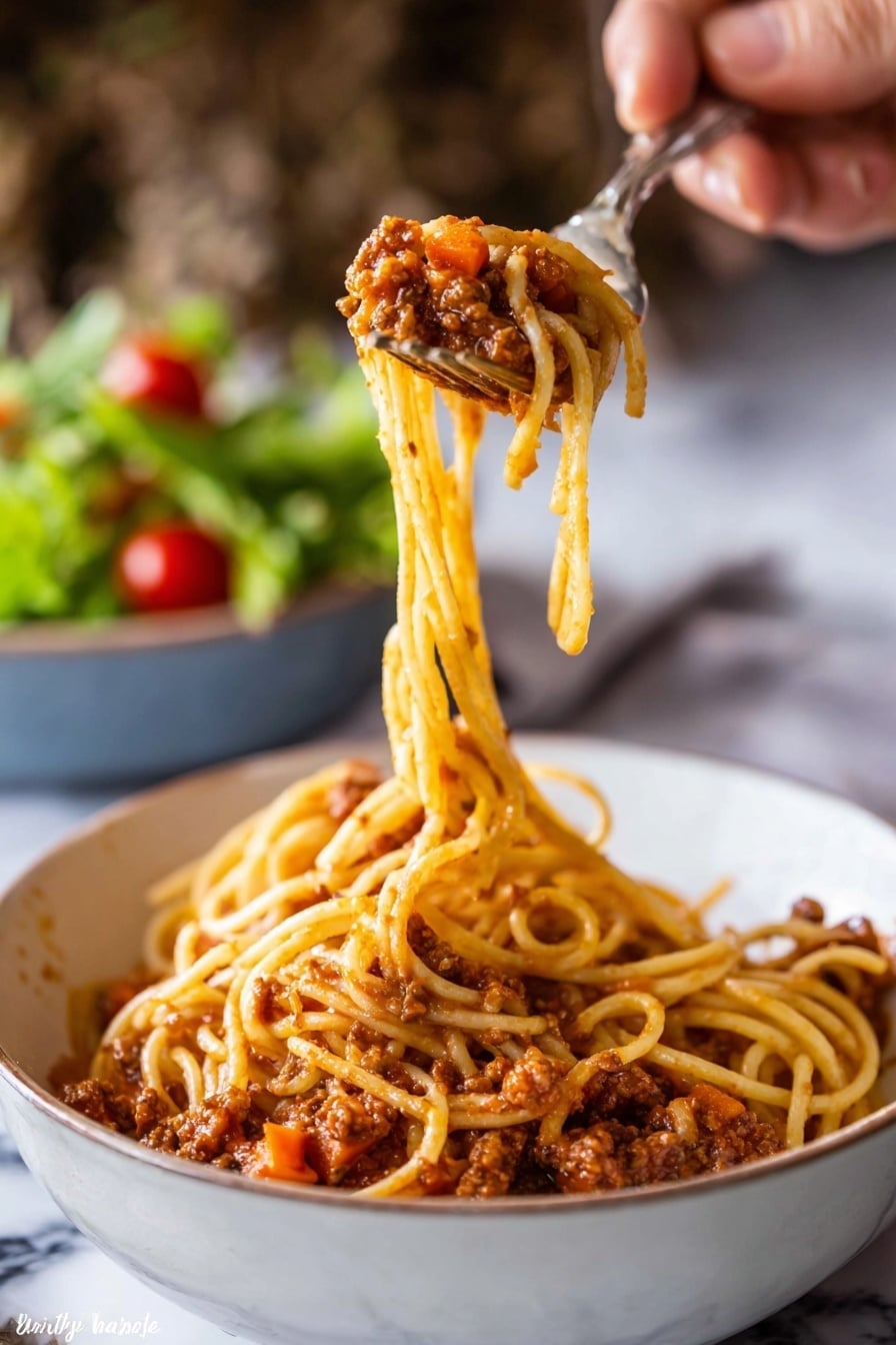 A close-up image shows a woman's hand holding a fork and spoon lifting a twirl of spaghetti from a white bowl filled with spaghetti bolognese. The spaghetti's long, thin yellow noodles are covered in a chunky, reddish-brown tomato sauce with visible bits of carrots and minced meat. The sauce coats the bottom layer of the bowl, creating a textured base under the lifted pasta. In the background, a blurred bowl of green salad with cherry tomatoes sits on a white marbled surface. The image focuses on the pasta being lifted, highlighting the sauce's texture and pasta's smooth strands. Photo taken with an iphone --ar 2:3 --v 7 - Slow Cooker Bolognese Sauce, hearty slow cooker Bolognese, easy slow cooker pasta sauce, flavorful beef Bolognese, beginner-friendly slow cooker sauce