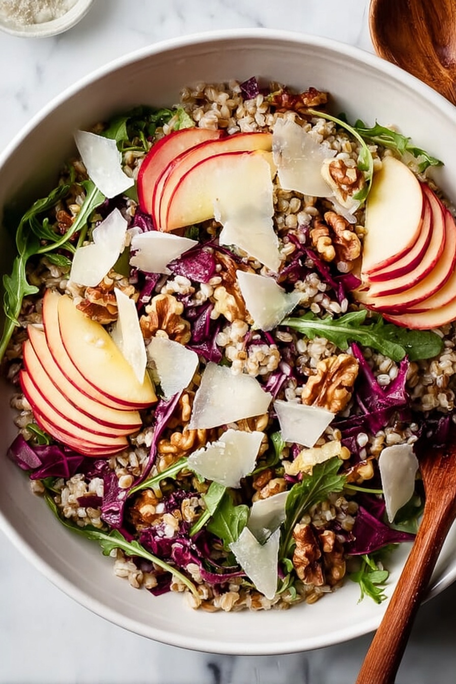 A white bowl filled with a colorful salad sitting on a white marbled surface. The salad has several layers: at the base there are light brown grains spread evenly, mixed with thin dark purple-red cabbage strips and bright green arugula leaves scattered throughout. On top of this are thin slices of red apple with white inside, placed around the bowl. There are also chunks of light brown walnuts spread across, and thin, uneven white cheese shavings scattered over everything. A wooden spoon is partly visible on the right side of the bowl. photo taken with an iphone --ar 2:3 --v 7 - Nutty Farro Salad with Apples and Arugula, healthy farro salad, apple and arugula salad recipe, nutritious grain salad, easy wholesome salads