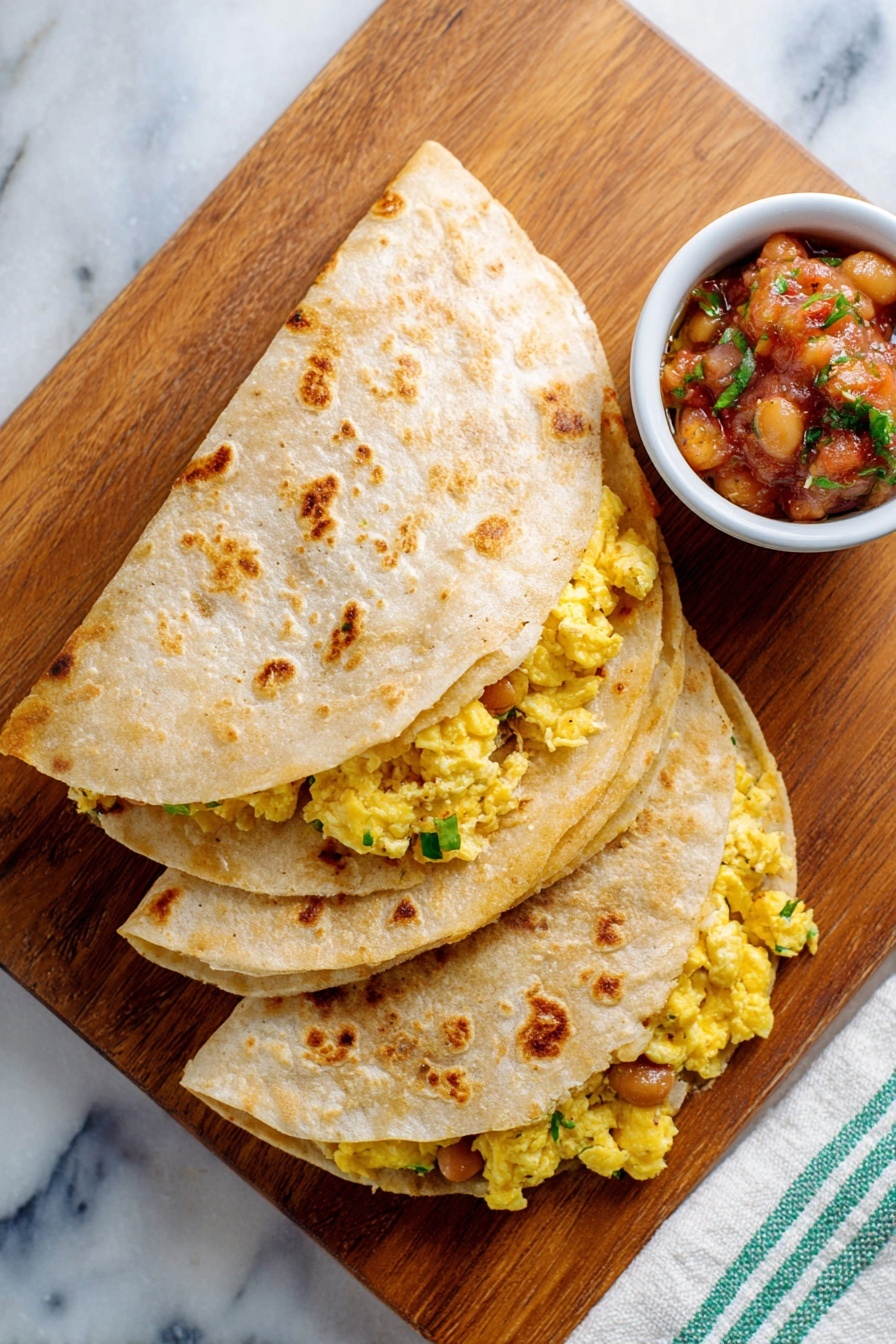 Two folded tortillas, each with two layers visible: the outer layer is a light tan with toasted brown spots, and inside there is a bright yellow scrambled egg mixture with gooey melted cheese and brown beans mixed with bits of green herbs, all peeking out slightly from under the tortillas. Behind the tortillas is a white bowl with blue patterns filled with chunky salsa showing red tomato, green herbs, and other diced vegetables. Everything is on a wooden board placed on a white marbled surface. Photo taken with an iphone --ar 2:3 --v 7 - Easy Breakfast Egg and Bean Quesadilla, breakfast quesadilla recipe, quick morning breakfast, protein-packed breakfast, healthy breakfast ideas