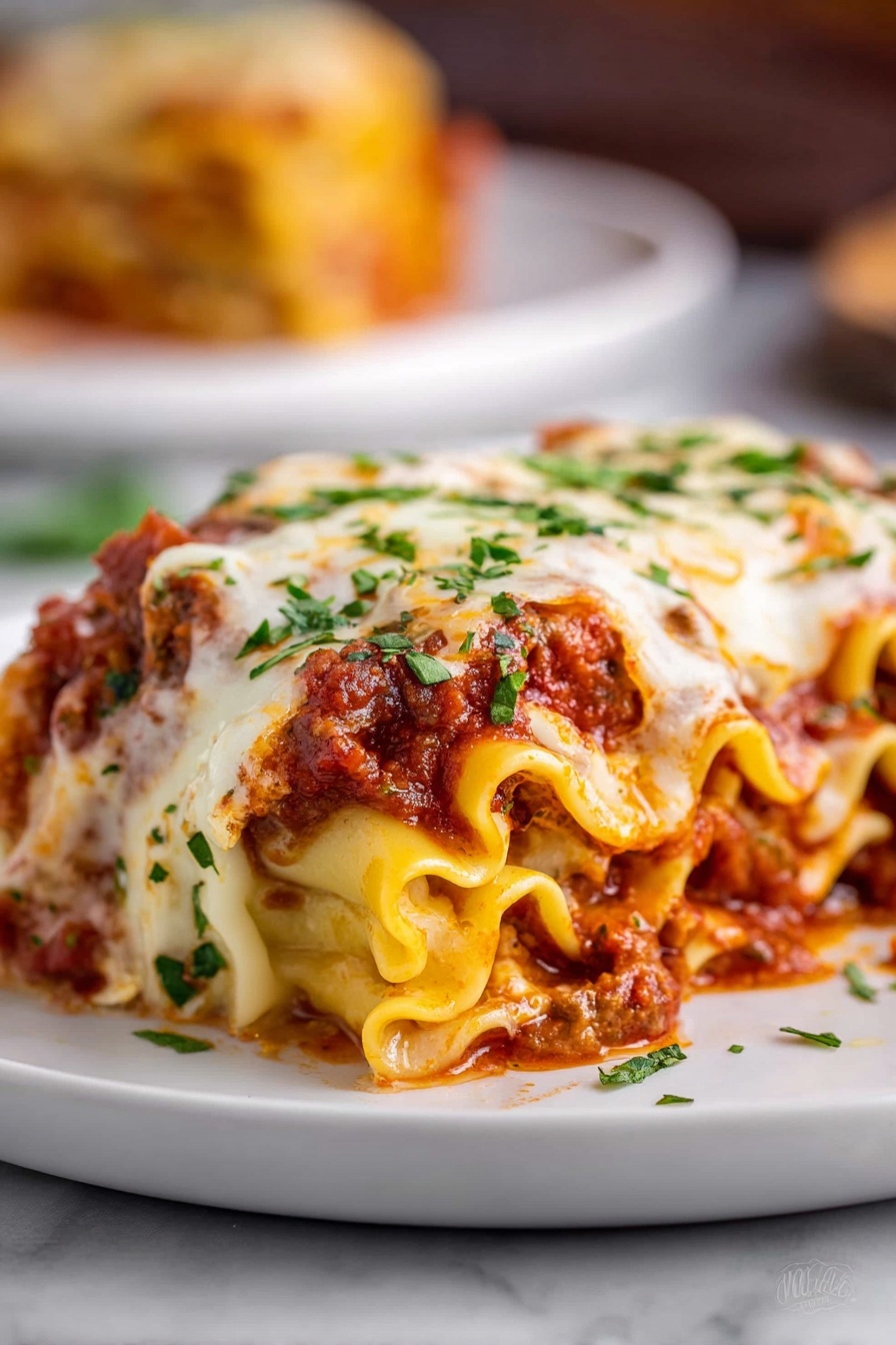 The image shows a close-up of a rolled lasagna piece on a white plate, placed over a white marbled surface. The lasagna has many wavy layers of soft, yellow pasta filled with a thick red meat sauce and melted cheese. The top is covered with a layer of creamy white melted cheese that is slightly browned in spots, sprinkled with bright green chopped herbs. The sauce peeks through the edges of the pasta rolls, adding a rich red color to the dish. In the blurred background, part of another portion is visible on a similar white plate. Photo taken with an iphone --ar 2:3 --v 7 - Cheesy Beef Lasagna Roll Ups, Italian roll ups, cheesy beef pasta, easy lasagna dish, family-friendly lasagna