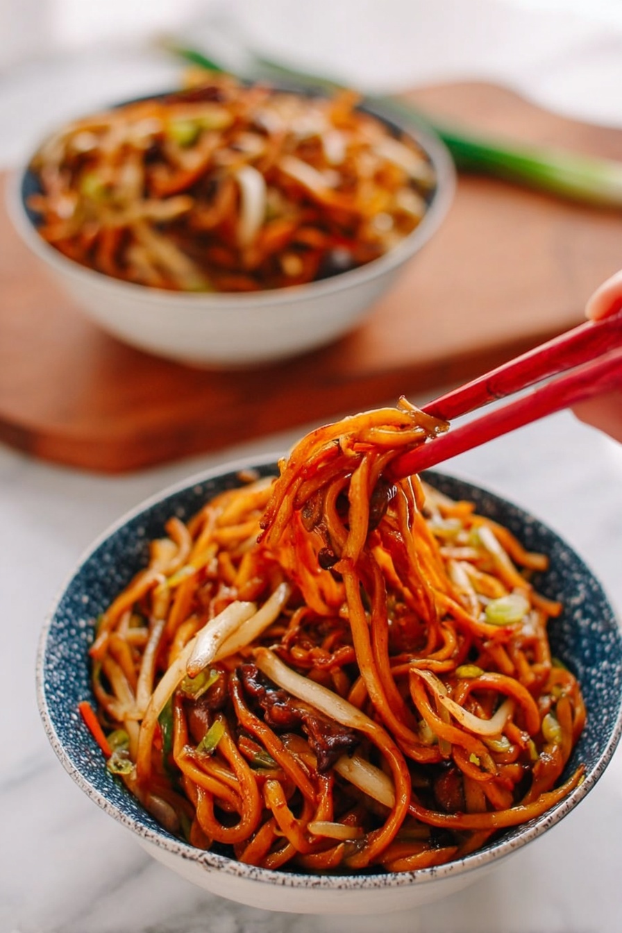 A bowl of noodles sits on a white marbled surface, filled with thick, orange-brown noodles mixed with thin white and light tan vegetables, all coated in a shiny sauce. A woman's hand is holding red chopsticks lifting a tangled cluster of noodles with bits of vegetables and darker brown mushroom-like pieces peeking through. In the background, another bowl filled with the same noodle dish is slightly blurred. The bowls are white with a blue speckled pattern on the outside, and a wooden cutting board with some green onion is faintly seen behind them. photo taken with an iphone --ar 2:3 --v 7 - Restaurant-Style Chicken Lo Mein, chicken lo mein recipe, Chinese chicken lo mein, easy lo mein stir-fry, homemade Chinese noodles