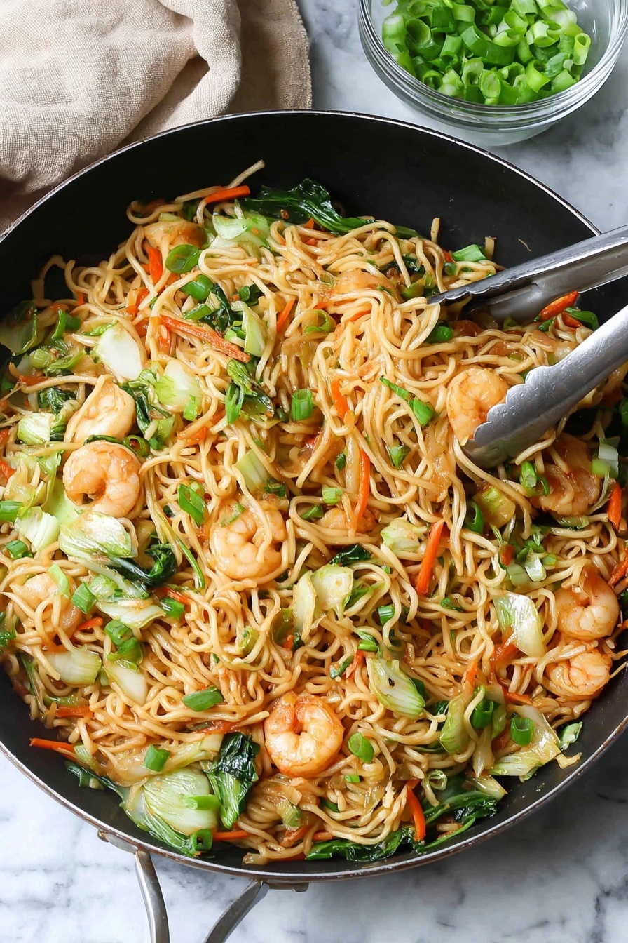 A large black pan is filled with a colorful stir-fry of noodles, shrimp, and vegetables. The base layer has light brown noodles that are thin and mixed with bright green pieces of bok choy and carrot sticks in orange. On top are pink shrimp, slightly browned with black pepper sprinkled on them, scattered throughout. Small pieces of green onions are spread over the whole dish, adding fresh green color. Chopsticks hold a small bundle of noodles and shrimp above the pan. In the background, a small clear glass bowl holds more green onions, and a light wooden pepper grinder is visible. The scene sits on a white marbled textured surface with a light gray cloth napkin beside the pan photo taken with an iphone --ar 2:3 --v 7 - Shrimp Lo Mein Stir Fry, easy shrimp stir fry recipe, Chinese takeout style noodles, quick shrimp lo mein, healthy shrimp stir fry