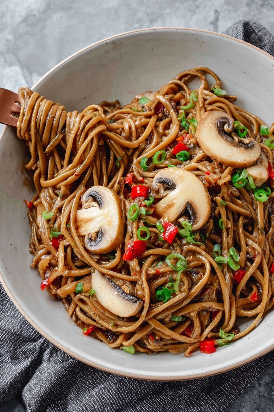 A white bowl is filled with thick noodles coated in a glossy brown sauce, mixed with small pieces of red bell pepper and garnished with finely chopped green onions. On top, there are three large slices of light brown mushrooms with darker edges, laid out neatly. A copper fork is twirling some noodles on the lower left side of the bowl. The bowl sits on a soft grey cloth on a white marbled surface. photo taken with an iphone --ar 2:3 --v 7 - Vegan Kung Pao Pasta with Mushrooms, vegan pasta recipes, spicy mushroom pasta, plant-based Kung Pao sauce, quick vegan dinner ideas