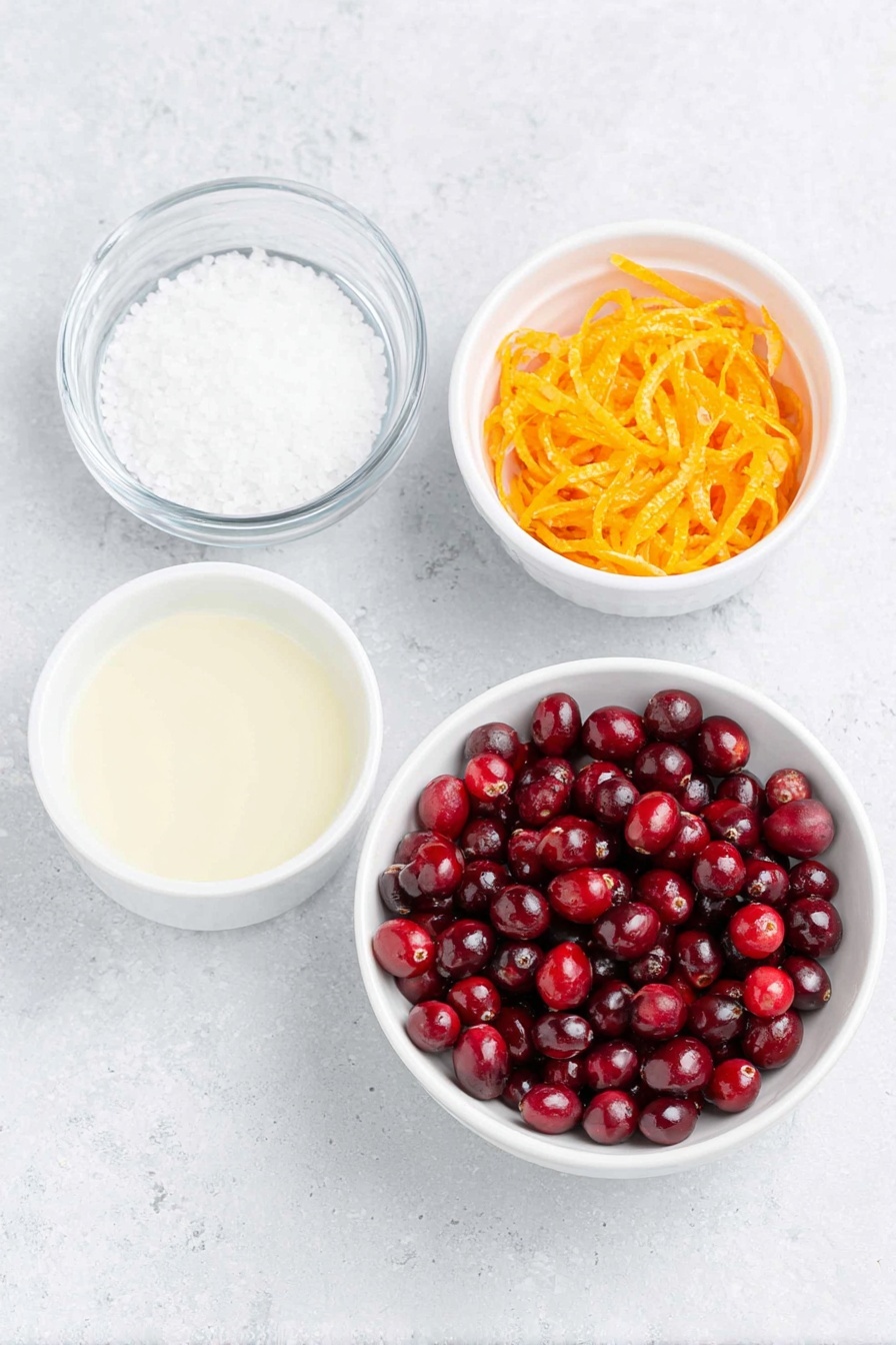 Flat lay of fresh, glossy red cranberries scattered alongside a small white ceramic bowl filled with granulated white sugar, a small white ceramic bowl containing bright, freshly squeezed orange juice, a simple white ceramic bowl with clear water, and a neat pile of vibrant orange zest strips, all arranged with perfect symmetry on a clean white marble surface, soft natural light, photo taken with an iPhone, professional food photography style, fresh ingredients, white ceramic bowls, no bottles, no duplicates, no utensils, no packaging --ar 2:3 --v 7 --p m7354615311229779997 - Easy Homemade Cranberry Sauce, homemade cranberry sauce, holiday cranberry sauce, quick cranberry sauce recipe, festive cranberry side dish