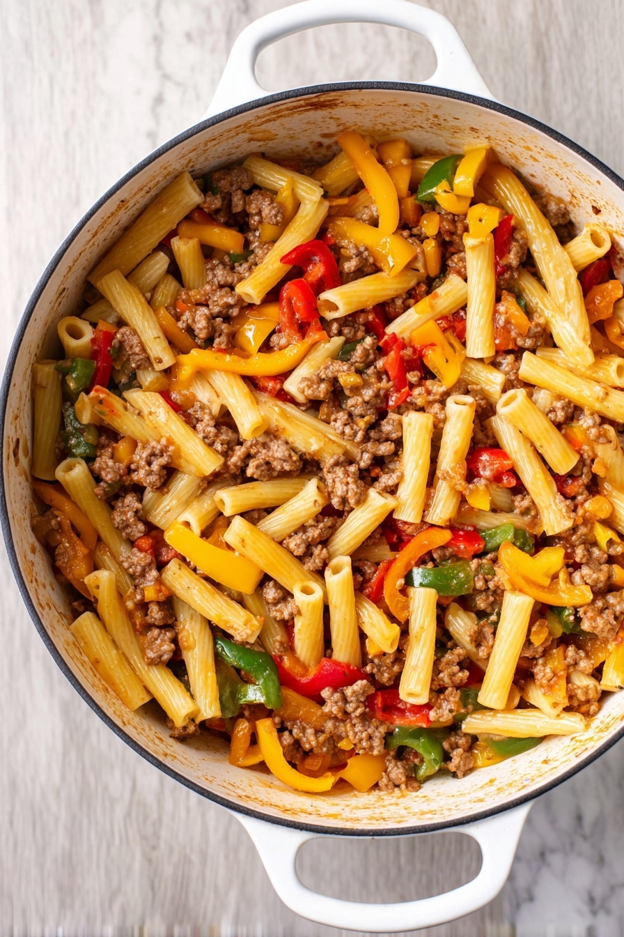 This image shows a white pot filled with a pasta dish featuring about three layers of ingredients. The bottom layer is short, tube-shaped pasta in a light yellow color. On top of this, there are chunks of cooked ground meat scattered throughout, appearing brown and crumbly. The top layer is mixed vegetables, including strips of red, yellow, and green bell peppers, adding bright colors and a fresh texture. The pot has white handles and sits on a white marbled surface. Photo taken with an iphone --ar 2:3 --v 7 - Italian Sausage and Peppers Pasta, Italian sausage pasta recipe, quick Italian pasta dinner, flavorful sausage pasta, easy sausage and peppers dish