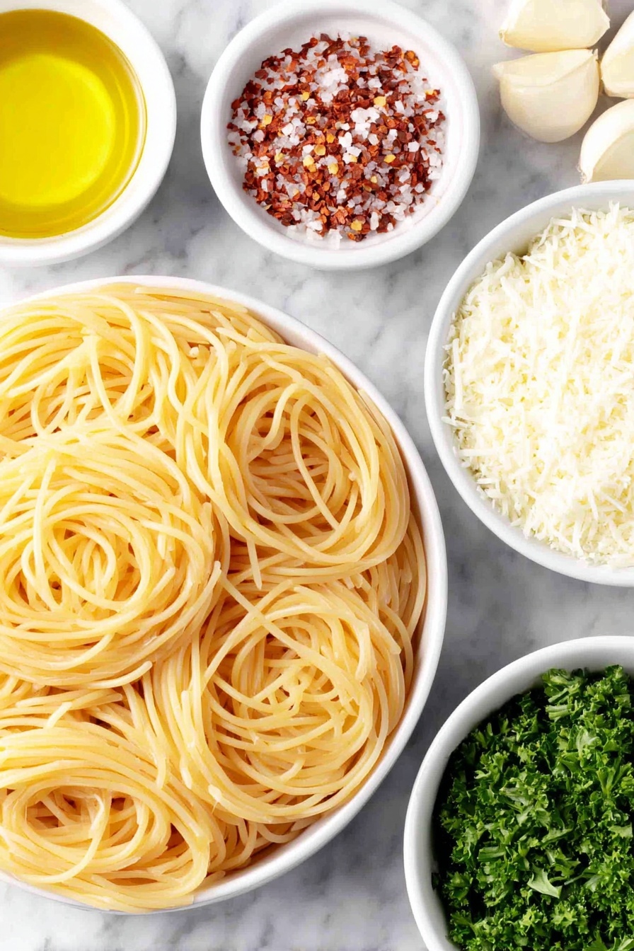 Flat lay of dried spaghetti coils arranged neatly beside a small white ceramic bowl filled with golden olive oil, a few thinly sliced garlic cloves spread out fresh and pale, a small white bowl holding bright red crushed red pepper flakes, a small white bowl of freshly grated Parmesan cheese with fine texture, and a handful of chopped vibrant green parsley leaves scattered naturally, all placed on a clean white marble surface, soft natural light, photo taken with an iPhone, professional food photography style, fresh ingredients, white ceramic bowls, no bottles, no duplicates, no utensils, no packaging --ar 2:3 --v 7 --p m7354615311229779997 - Garlic Spaghetti Aglio e Olio, easy garlic pasta, quick spaghetti recipes, simple Italian pasta, flavorful garlic spaghetti