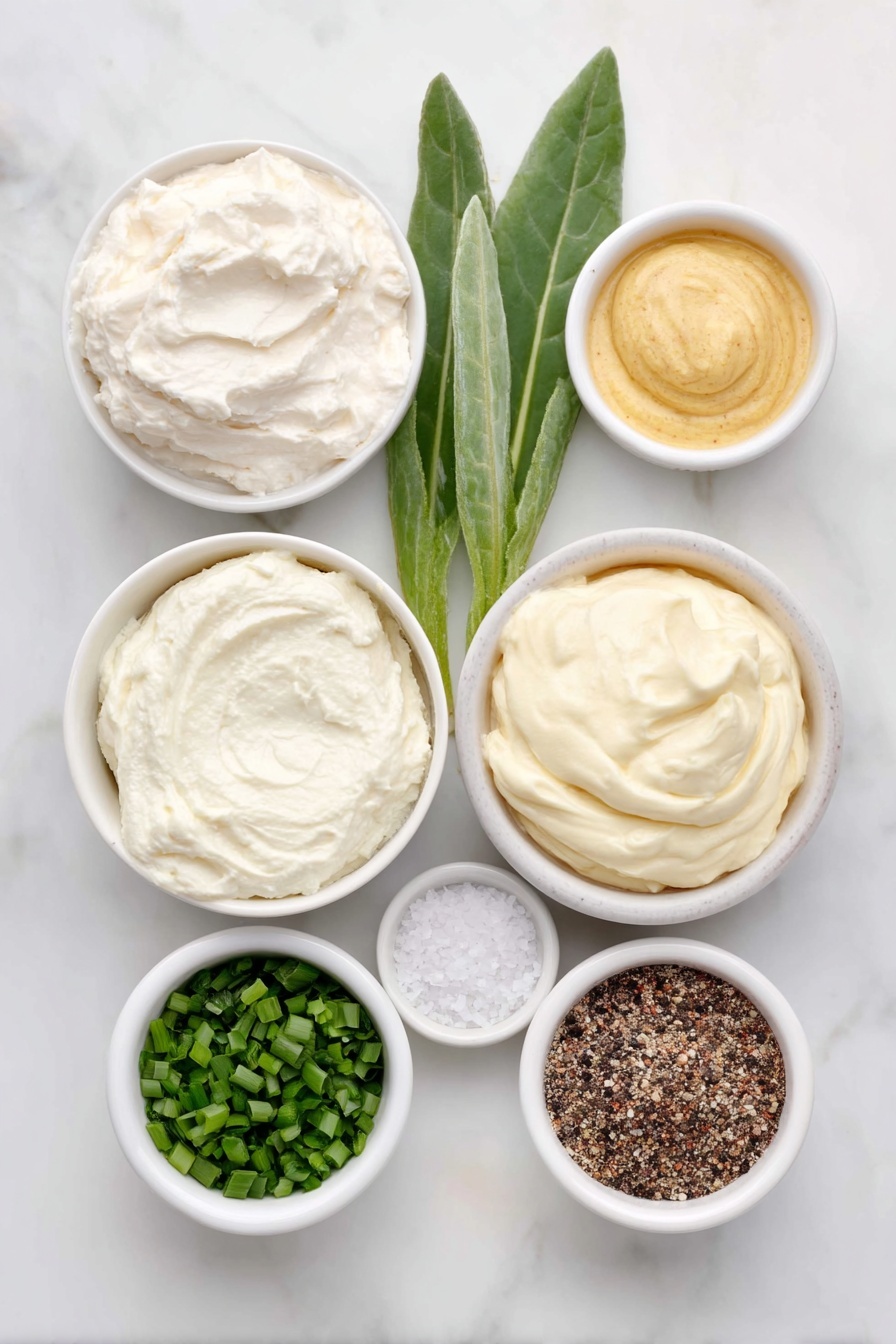 Flat lay of a small white ceramic bowl of creamy sour cream, a small white ceramic bowl with a dollop of prepared horseradish root next to a few fresh horseradish leaves, a small white ceramic bowl of smooth mayonnaise, a small white ceramic bowl containing bright green finely chopped chives, a small white ceramic bowl of golden Dijon mustard, a small white ceramic bowl with coarse kosher salt crystals, and a small white ceramic bowl with freshly ground black pepper, all arranged symmetrically and balanced, placed on a clean white marble surface, soft natural light, photo taken with an iPhone, professional food photography style, fresh ingredients, white ceramic bowls, no bottles, no duplicates, no utensils, no packaging --ar 2:3 --v 7 --p m7354615311229779997 - Creamy Horseradish Sauce for Prime Rib, horseradish sauce for roast beef, easy prime rib sauce, quick horseradish sauce recipe, flavorful prime rib condiment