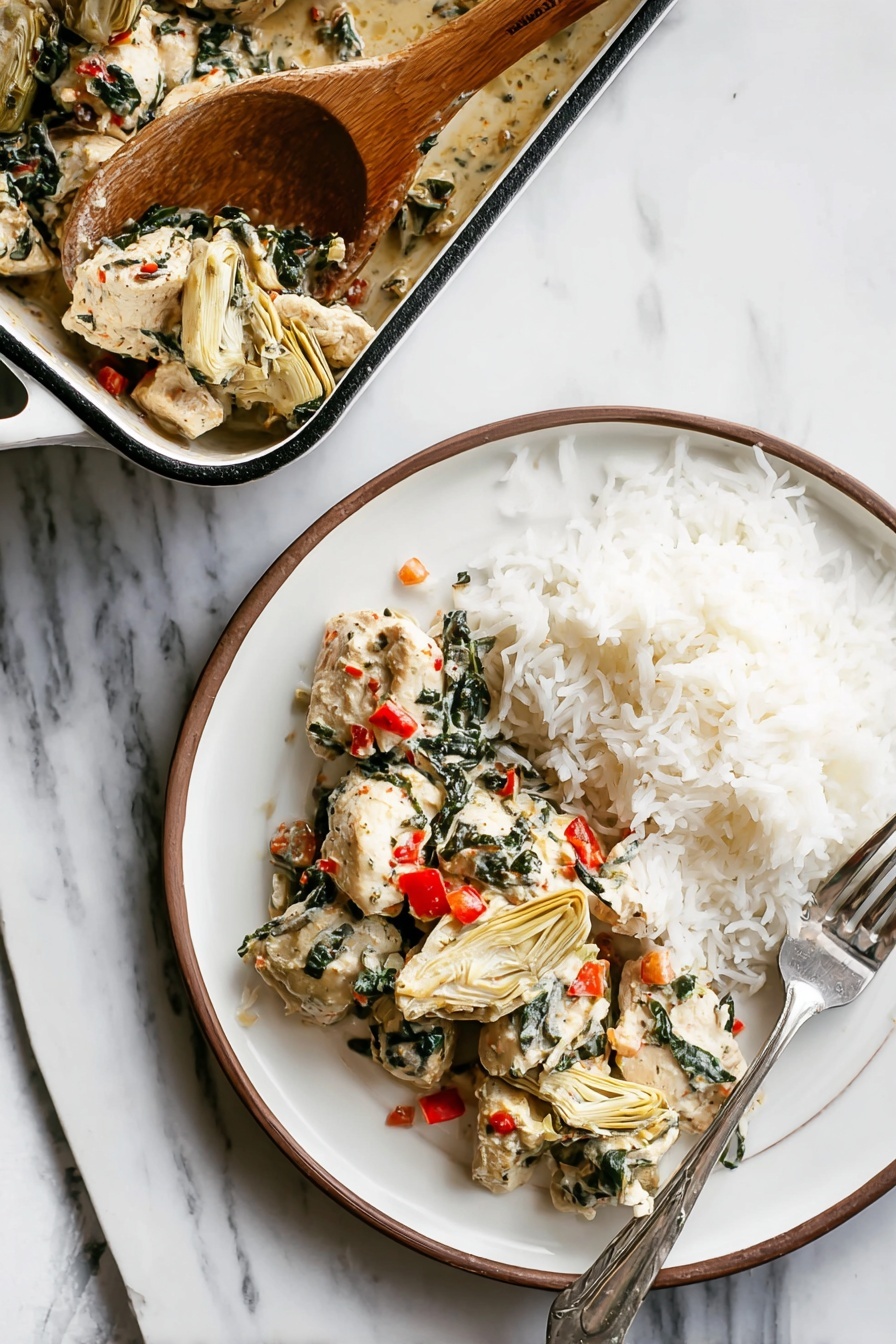A white round plate shows two layers: on the left side, there are pieces of white cooked chicken mixed with dark green spinach leaves and small bright red bits of bell pepper, along with beige artichoke hearts placed among the chicken; on the right side, there is a mound of fluffy white rice with a silver fork resting on the right edge of the plate. Above the plate, a white rectangular baking dish with a dark rim holds more chicken mixture, and a wooden spoon is scooping some of the chicken and vegetables from the dish. All items are placed on a white marbled surface. photo taken with an iphone --ar 2:3 --v 7 - Spinach Artichoke Chicken Bake, healthy chicken casserole, easy weeknight dinner, baked chicken with spinach and artichokes, creamy garlic chicken