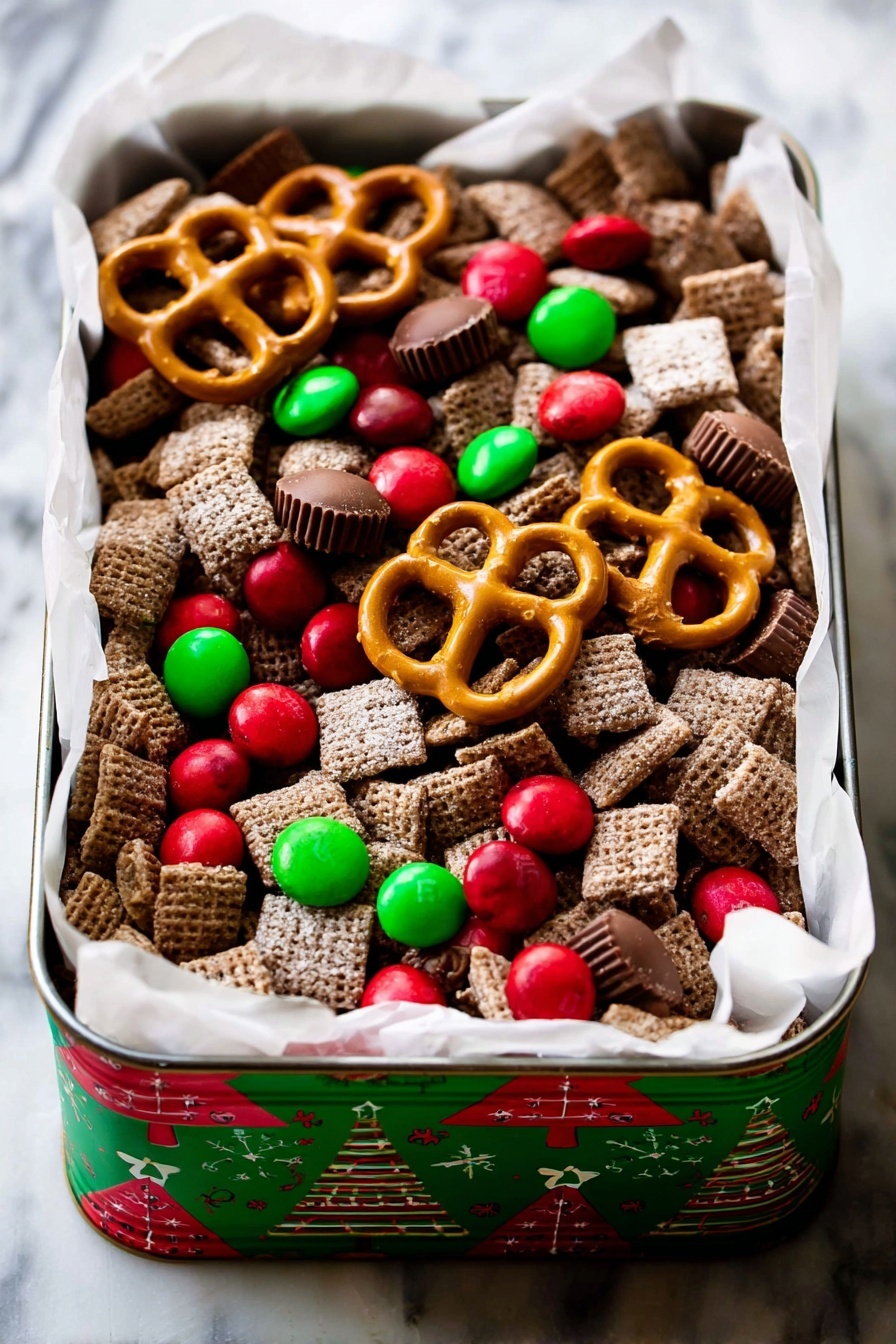 A rectangular tin with Christmas tree designs on the sides holds a festive snack mix. The mix contains many layers of square, brown, sugar-coated cereal pieces forming the base layer. Scattered on top are bright red and green candy-coated chocolates, some round and some smaller. Large golden-brown pretzels are placed unevenly across the top layer, along with several small, smooth milk chocolate peanut butter cups. The tin is lined with white parchment paper that spills over the edges slightly, all set on a white marbled surface. photo taken with an iphone --ar 2:3 --v 7 - Chocolate Peanut Butter Reindeer Chow, holiday snack mix, festive chocolate snack, quick holiday treat, crunchy holiday cookies