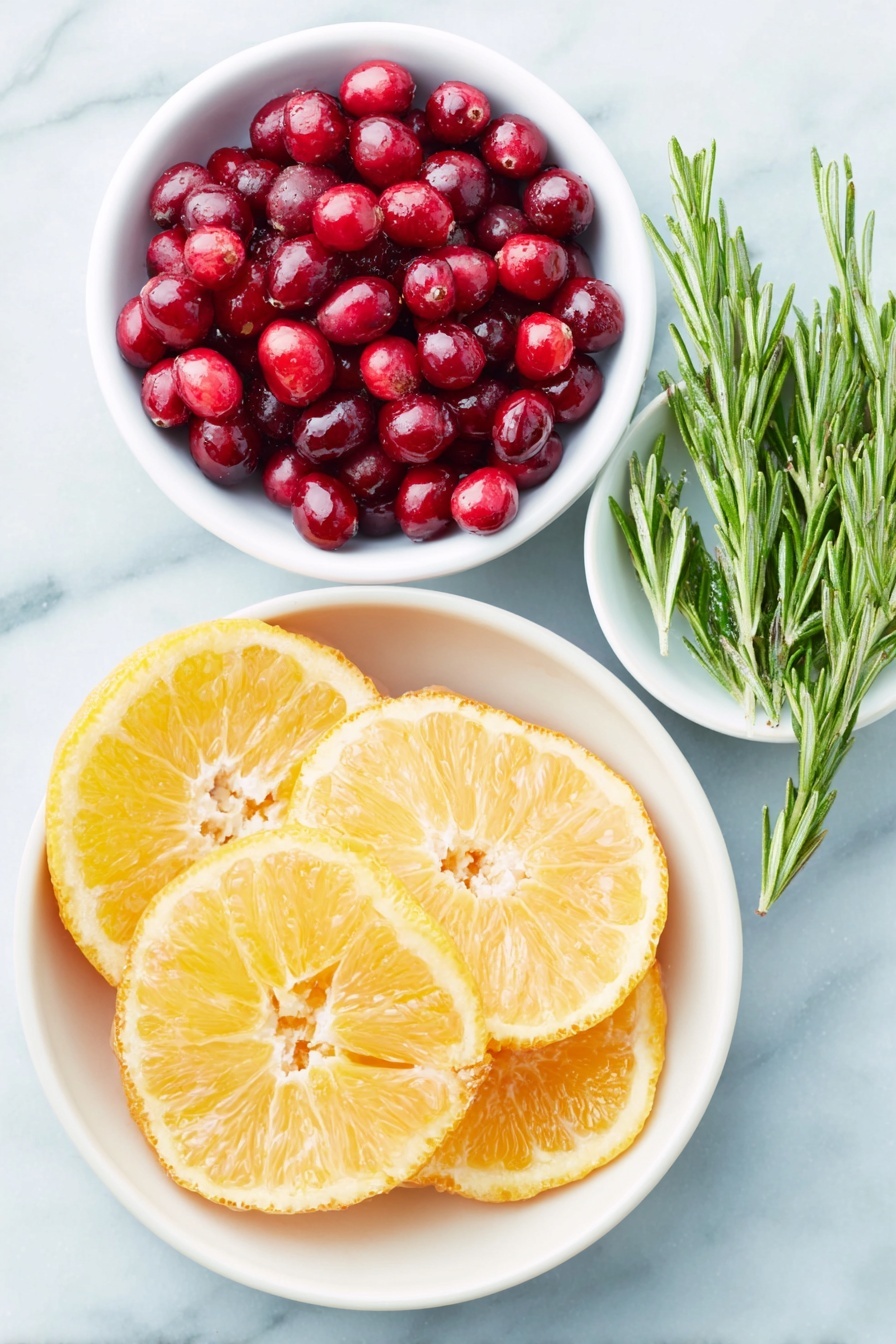 Flat lay of fresh orange slices arranged in a simple white ceramic bowl, a small white bowl filled with bright red cranberries, a small white bowl holding glossy pomegranate seeds, fresh rosemary sprigs laid neatly beside the bowls, all placed on a clean white marble surface, soft natural light, photo taken with an iPhone, professional food photography style, fresh ingredients, white ceramic bowls, no bottles, no duplicates, no utensils, no packaging --ar 2:3 --v 7 --p m7354615311229779997 - Festive Holiday Cranberry Orange Punch, holiday drink recipes, Christmas party punch, refreshing holiday beverages, easy holiday punch