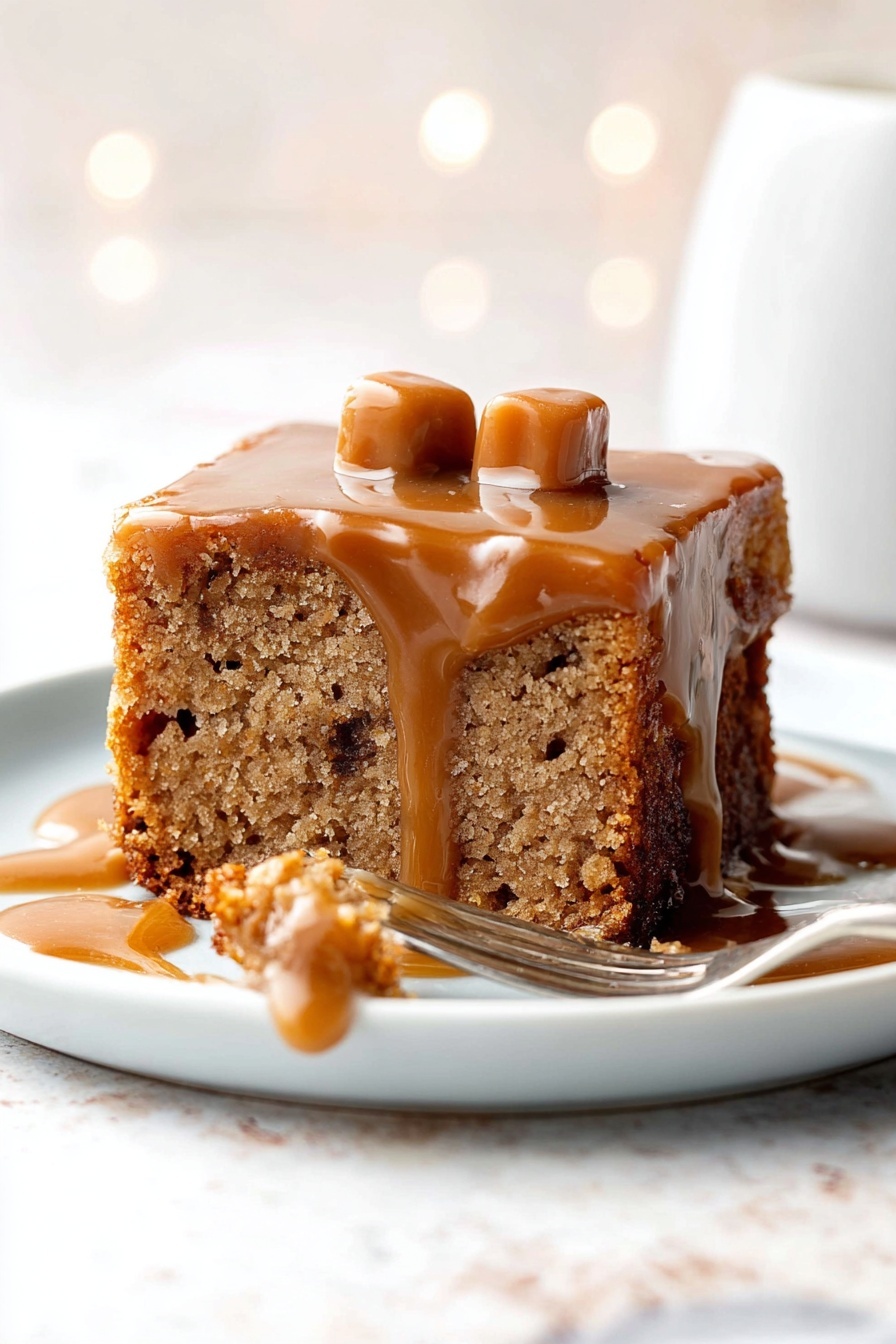 The image shows a square piece of light brown cake with visible texture and small darker spots inside, placed on a white plate. The cake has a layer of shiny caramel sauce dripping down its sides, slightly pooling on the plate. On top of the cake, there are two small, light tan caramel candies. A fork lies on the right side of the plate, with a small bite of the cake covered with caramel sauce resting near it. The background has a white marbled texture and soft bokeh light effects. Photo taken with an iphone --ar 2:3 --v 7 - Sticky Toffee Pudding with Toffee Sauce, comforting dessert recipes, easy toffee pudding, moist date pudding, homemade toffee sauce