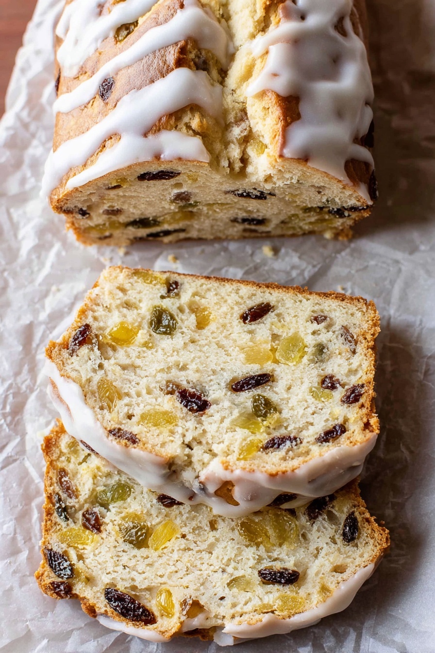The image shows a loaf of sweet bread with a golden-brown top covered with white icing drizzled over it. The bread is sliced into three pieces, revealing a soft, light beige inside filled with bits of dark raisins and light yellow fruit pieces evenly spread throughout. The bread sits on crumpled parchment paper placed on a white marbled surface, and the slices have a slightly rough texture with visible fruit chunks inside. The crust looks thin and slightly shiny beneath the icing. Photo taken with an iphone --ar 2:3 --v 7 - German Stollen Bread, traditional holiday bread, festive German cake, Christmas stollen recipe, homemade Stollen bread
