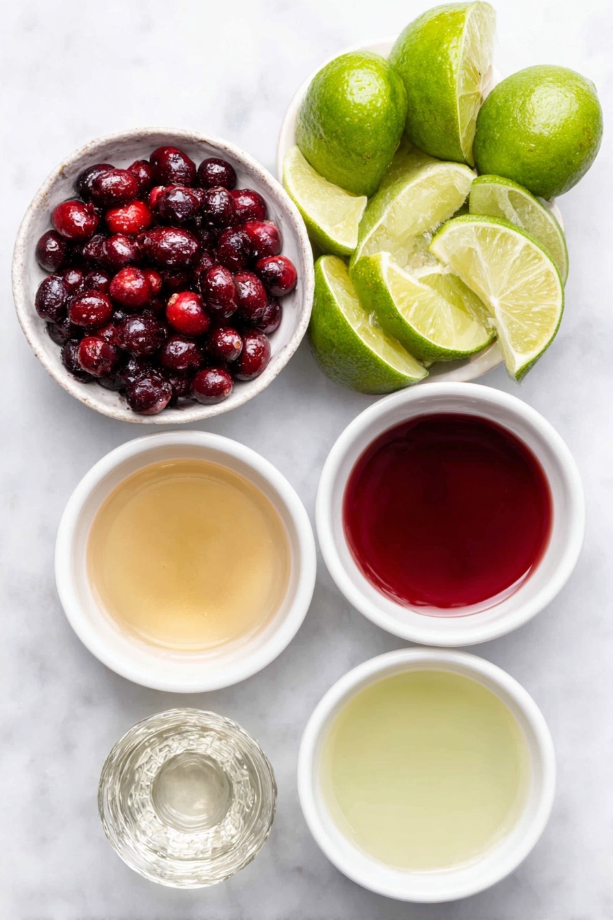 Flat lay of fresh whole lime wedges arranged neatly, a small white ceramic bowl filled with bright red fresh cranberries, a small white bowl containing clear simple syrup, a small white bowl of vibrant red cranberry juice, a small white bowl of pale green fresh lime juice, and a small white bowl with clear silver tequila, placed on a clean white marble surface, soft natural light, photo taken with an iPhone, professional food photography style, fresh ingredients, white ceramic bowls, no bottles, no duplicates, no utensils, no packaging --ar 2:3 --v 7 --p m7354615311229779997 - Christmas Cranberry Margarita, festive holiday margarita, easy holiday cocktails, cranberry margarita recipe, Christmas party drinks