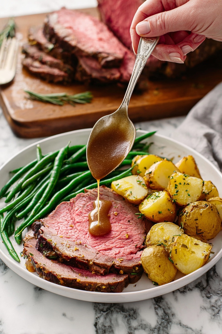 A white plate holds a meal with three layers: a large slice of pink roast beef with a browned edge forms the base layer, topped with bright green cooked green beans arranged in a neat pile along one side, and golden roasted potato chunks with herbs sit next to the green beans. A woman's hand holds a silver spoon above the beef, pouring rich brown gravy directly onto the meat. In the background, a wooden board with a large piece of roast beef resting on it is visible against a white marbled surface. Photo taken with an iphone --ar 2:3 --v 7 - Garlic Herb Prime Rib Roast, prime rib dinner, holiday prime rib, tender beef roast, herb-crusted prime rib