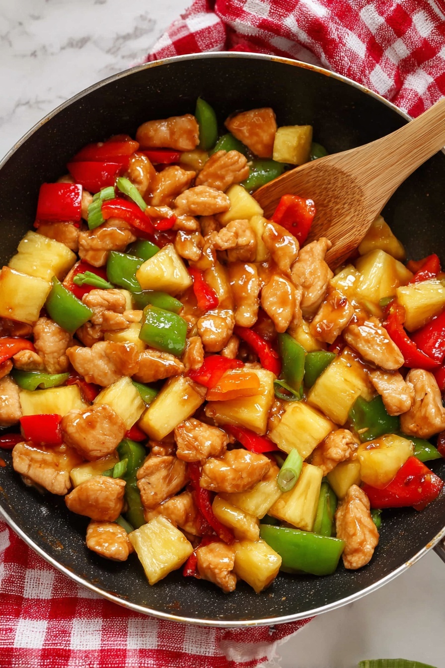 A white oval plate contains a dish with two main layers. The bottom layer is a bed of steamed white rice, with soft, fluffy grains. On top, there is a thick mixture of bite-sized golden brown chicken pieces coated in a shiny sauce, large chunks of bright yellow pineapple, green bell pepper pieces with a smooth shine, and irregular slices of red bell pepper. The vegetables and chicken are mixed evenly, creating a colorful and glossy topping over the rice. The plate sits on a white marbled surface, with a red and white checkered cloth partially visible to the side. Photo taken with an iphone --ar 2:3 --v 7 - Easy Sweet and Sour Chicken, sweet and sour chicken recipe, quick chicken dinner, healthy sweet and sour chicken, flavorful chicken recipes