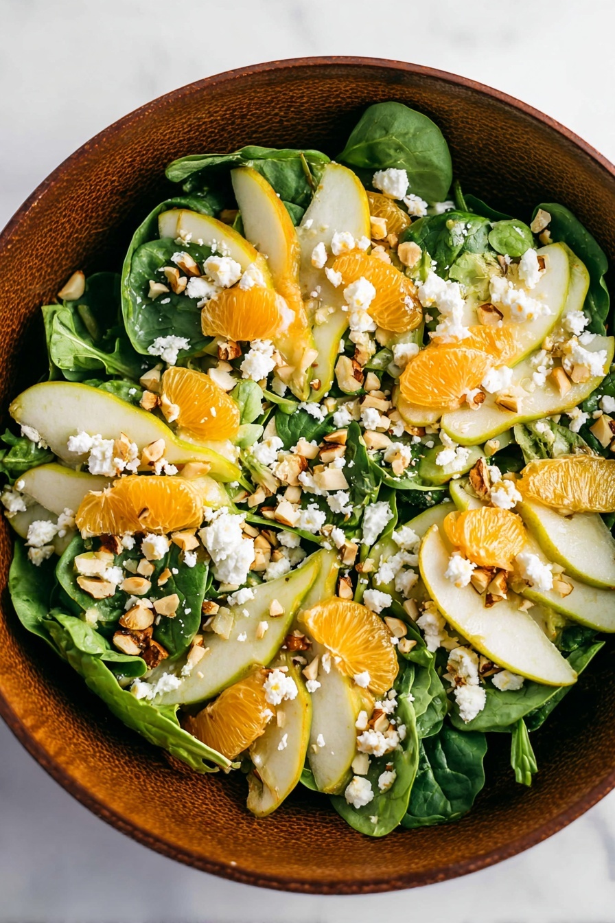 A round brown bowl filled with fresh green spinach leaves as the bottom layer, topped with thin slices of light green pear and bright orange segments arranged evenly on top. White crumbled cheese is scattered over the fruit and greens, mixed with small chopped nuts and chopped fresh green herbs sprinkled over all layers, adding texture and color contrast. The bowl sits on a white marbled surface. photo taken with an iphone --ar 2:3 --v 7 - Irish Flag Salad with Oranges and Pears, vibrant fruit salad recipe, healthy layered fruit salad, quick colorful salads, festive Irish-inspired salads