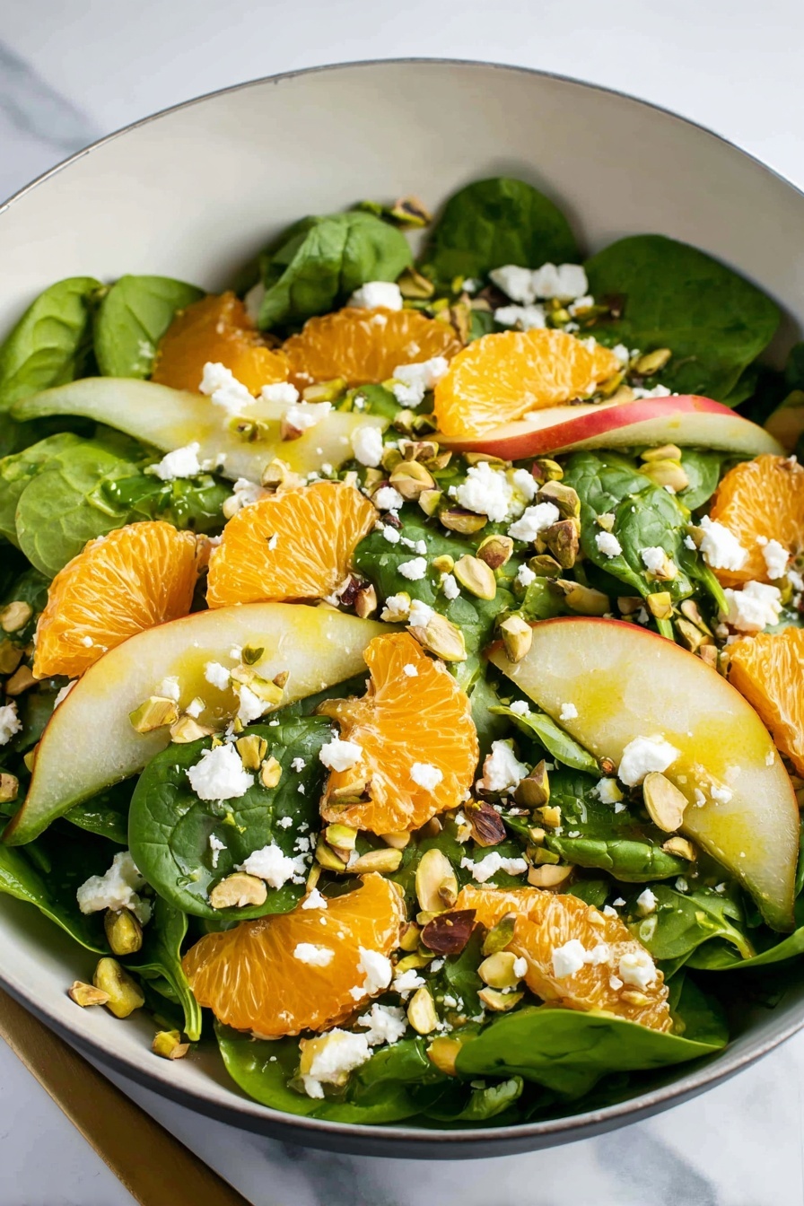 A white bowl filled with a fresh salad showing three main layers: the bottom layer is dark green spinach leaves with smooth textures, the middle layer contains thin slices of green pear and bright orange citrus segments with a juicy look, and the top layer is sprinkled with small white crumbles of cheese and chopped, light brown pistachio nuts. Small torn green herb leaves are scattered on top bringing more color and freshness to the dish, set on a white marbled surface. Photo taken with an iphone --ar 2:3 --v 7 - Irish Flag Salad with Oranges and Pears, vibrant fruit salad recipe, healthy layered fruit salad, quick colorful salads, festive Irish-inspired salads